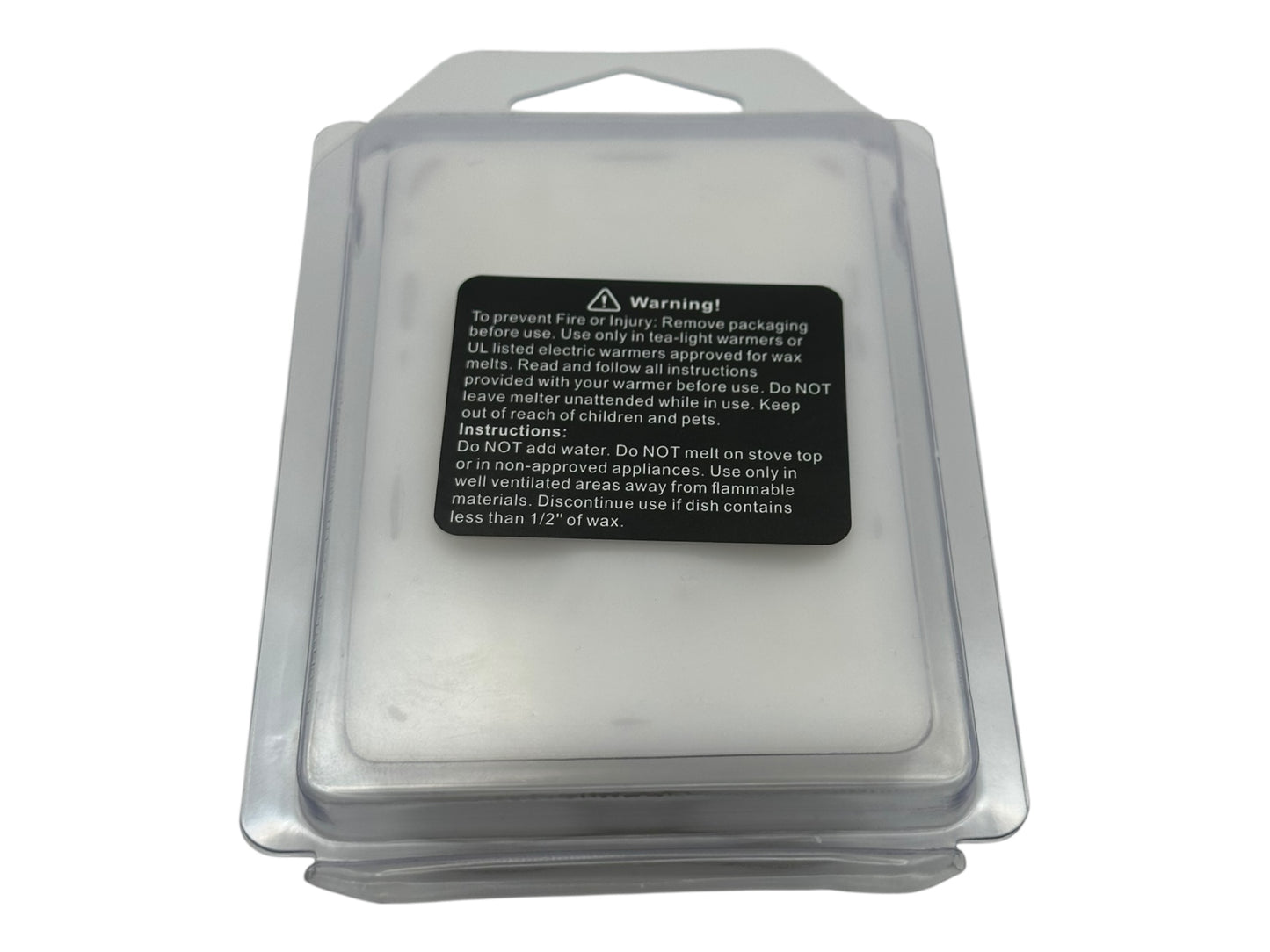 A white wax melt in a clear clamshell with a warning label.