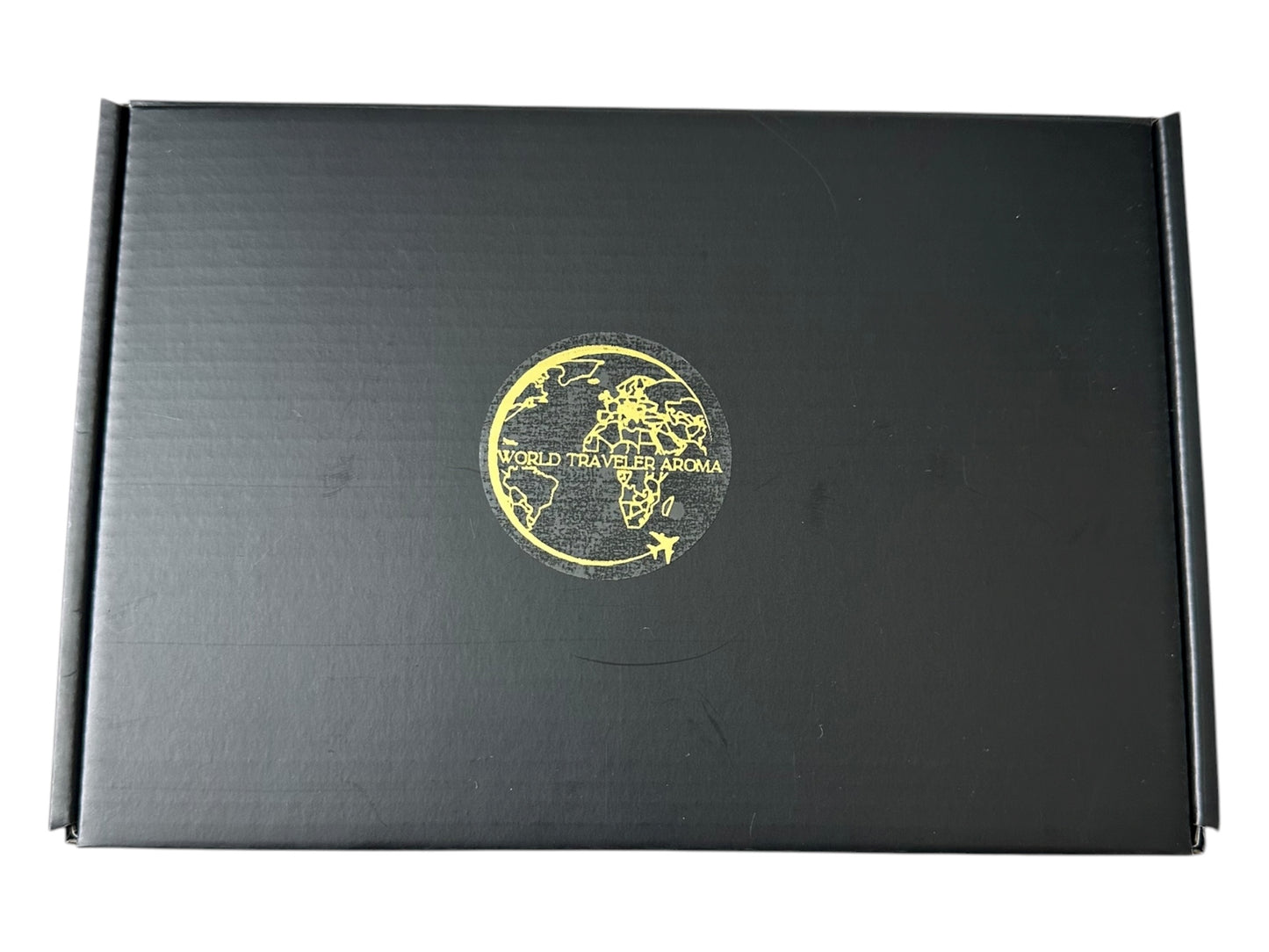 Black box with a gold globe design  World Traveler Aroma on a white background